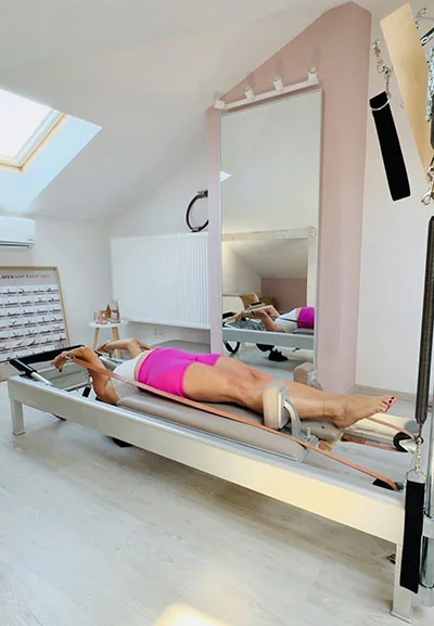 Ćwiczenie w leżeniu na reformerze w kameralnym studiu Pilates