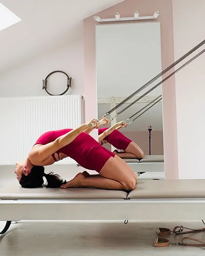 Ćwiczenie w klęku z wykorzystaniem sprężyn wieży w studiu Pilates